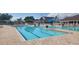 Large community pool with lap lanes and seating, ideal for swimming and socializing in a tropical setting at 13256 Creekside Ln, Port Charlotte, FL 33953