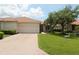 Inviting one-story home featuring a tile roof, brick driveway, and well-maintained lawn, creating a warm curb appeal at 13256 Creekside Ln, Port Charlotte, FL 33953