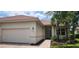 Charming single-story home with a tile roof, manicured landscaping, and an attached two-car garage at 13256 Creekside Ln, Port Charlotte, FL 33953