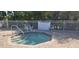 Inviting hot tub area enclosed by a white fence and surrounded by lush, tropical greenery at 13256 Creekside Ln, Port Charlotte, FL 33953