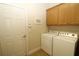 Functional laundry room with a washer, dryer, upper cabinets, and a tiled floor at 13256 Creekside Ln, Port Charlotte, FL 33953