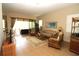 Comfortable living room showcasing tile floors, light walls, rattan furniture and sliding door access to the lanai at 13256 Creekside Ln, Port Charlotte, FL 33953