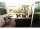 Relaxing screened-in patio featuring outdoor furniture and a view of the surrounding nature at 13256 Creekside Ln, Port Charlotte, FL 33953