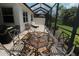 Screened lanai featuring an outdoor dining set with brick flooring overlooking the backyard at 13256 Creekside Ln, Port Charlotte, FL 33953