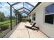 Covered screened lanai with brick floors, a lounge chair and seating area offering outdoor living at 13256 Creekside Ln, Port Charlotte, FL 33953