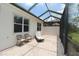 Screened-in patio with a lounge chair and seating area with brick flooring at 13256 Creekside Ln, Port Charlotte, FL 33953