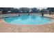 Large community pool with lounge chairs, umbrellas, and beautiful, tropical landscaping at 13256 Creekside Ln, Port Charlotte, FL 33953