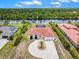Aerial view of a luxury home with a circular driveway, tile roof, and waterfront access with lush green surroundings at 13295 Eisenhower Dr, Port Charlotte, FL 33953