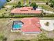 Aerial view showcasing a luxurious home with a pool, tile roof, and beautifully landscaped grounds in a waterfront setting at 13295 Eisenhower Dr, Port Charlotte, FL 33953