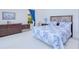 Bright bedroom features a bed with patterned bedsheets and a wood dresser at 13295 Eisenhower Dr, Port Charlotte, FL 33953