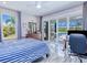 Bright bedroom offering backyard views and sliding glass doors leading to the pool area and lake at 13295 Eisenhower Dr, Port Charlotte, FL 33953