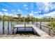 Wooden dock with a boat ramp along the canal, perfect for enjoying waterfront activities and serene views at 13295 Eisenhower Dr, Port Charlotte, FL 33953
