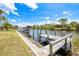 Waterfront property with a wooden dock, boat lift, and stunning canal views, perfect for boating and relaxation at 13295 Eisenhower Dr, Port Charlotte, FL 33953
