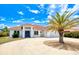 Inviting home featuring a modern front facade, well-manicured landscaping, a circular driveway and a red tile roof at 13295 Eisenhower Dr, Port Charlotte, FL 33953