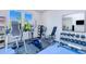 Bright home gym with exercise equipment, blue mat floors and ample natural light from a large window at 13295 Eisenhower Dr, Port Charlotte, FL 33953