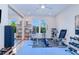 Home gym featuring modern exercise equipment, blue tile flooring, mirrored closet doors, and natural light from the window at 13295 Eisenhower Dr, Port Charlotte, FL 33953