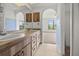 Bathroom featuring double sinks, wood cabinets and an arched view to bedroom at 1348 Rock Dove Ct # C201, Punta Gorda, FL 33950