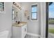 Bright half-bath with a modern vanity, marble countertop, and decorative lighting at 15148 Taurus Cir, Port Charlotte, FL 33981