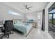 Modern bedroom featuring a ceiling fan, grey wood flooring, and sliding door access to an outdoor patio at 15148 Taurus Cir, Port Charlotte, FL 33981