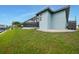 Well-maintained home exterior with a screened-in lanai, lush lawn, and canal access at 15148 Taurus Cir, Port Charlotte, FL 33981