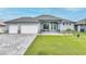 Beautiful single-story home with a three-car garage, well-manicured lawn, and a charming front entry at 15148 Taurus Cir, Port Charlotte, FL 33981