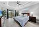 Comfortable main bedroom suite features a ceiling fan and access to the screened-in patio at 15148 Taurus Cir, Port Charlotte, FL 33981