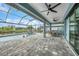 Expansive screened-in patio with pool and canal view, featuring sleek stone pavers at 15148 Taurus Cir, Port Charlotte, FL 33981
