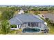 Backyard features screened-in pool, complemented by lush greenery and palm trees, creating a private oasis at 15890 Viscount Cir, Port Charlotte, FL 33981