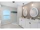 Bathroom boasts dual vanities, modern lighting, walk-in shower, and large picture window at 15890 Viscount Cir, Port Charlotte, FL 33981