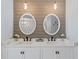 Elegant bathroom vanity with dual sinks, white cabinets, and modern lighting at 15890 Viscount Cir, Port Charlotte, FL 33981