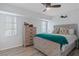 Bright bedroom with natural light, featuring a ceiling fan, wood-look floors, and a decorative accent wall at 15890 Viscount Cir, Port Charlotte, FL 33981