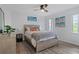 Bedroom with natural light features a ceiling fan, wood-look floors, and coastal artwork on the walls at 15890 Viscount Cir, Port Charlotte, FL 33981