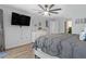 Bright bedroom with wood-look floors, large TV, and ensuite bathroom at 15890 Viscount Cir, Port Charlotte, FL 33981