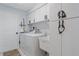 Bright laundry room features front load washer, dryer, sink, and ample white cabinet storage space at 15890 Viscount Cir, Port Charlotte, FL 33981