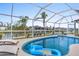 Screened-in pool area with lounge chairs and a view of the canal at 15890 Viscount Cir, Port Charlotte, FL 33981