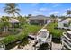 Backyard with a boat lift, dock, chairs, lush landscaping, and screened lanai at 1932 Los Alamos Dr, Punta Gorda, FL 33950