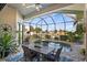 Screened lanai featuring a dining table and view of the pool and canal at 1932 Los Alamos Dr, Punta Gorda, FL 33950