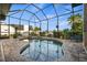 Screened-in pool and spa offers a relaxing space with stone flooring and tropical landscaping at 1932 Los Alamos Dr, Punta Gorda, FL 33950