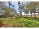 Beautiful backyard with lush green grass, mature trees, and plenty of space for outdoor activities at 2028 Lynx Run, North Port, FL 34288