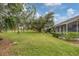 Expansive backyard featuring lush lawn, mature trees, and tranquil views of the well-maintained community grounds at 2028 Lynx Run, North Port, FL 34288