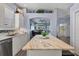 Kitchen featuring white cabinets, stainless appliances, granite countertops, and decor shelf above cabinets at 2028 Lynx Run, North Port, FL 34288