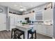 Bright kitchen with white cabinetry, stainless appliances, center island with seating, and stylish backsplash at 2028 Lynx Run, North Port, FL 34288