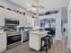 The charming kitchen features white cabinetry, an island with seating, stainless appliances and decor shelving at 2028 Lynx Run, North Port, FL 34288