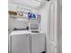 Practical laundry room with washer, dryer, and shelving for ample storage at 2028 Lynx Run, North Port, FL 34288