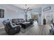 Comfortable living room with gray couches, ceiling fan, and view to screened patio with outdoor seating at 2028 Lynx Run, North Port, FL 34288