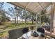 Enclosed screened patio with a table, chairs, and peaceful outdoor view at 2028 Lynx Run, North Port, FL 34288