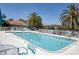 Sparkling community pool featuring ample lounge chairs and tables for relaxing by the water at 2028 Lynx Run, North Port, FL 34288