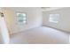 Bright, carpeted bedroom with two windows and a ceiling fan at 2028 River Basin Ter, Punta Gorda, FL 33982