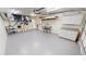 Large garage with painted floor, mechanics area, shelving and door to the backyard at 2028 River Basin Ter, Punta Gorda, FL 33982