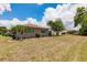 Large backyard with a view of the home and surrounding landscaping at 2365 Nuremberg Blvd, Punta Gorda, FL 33983